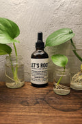 rooting hormones in a bottle sitting next to 3 jars or water all with plants that are rooting very fast and nigmce white roots.